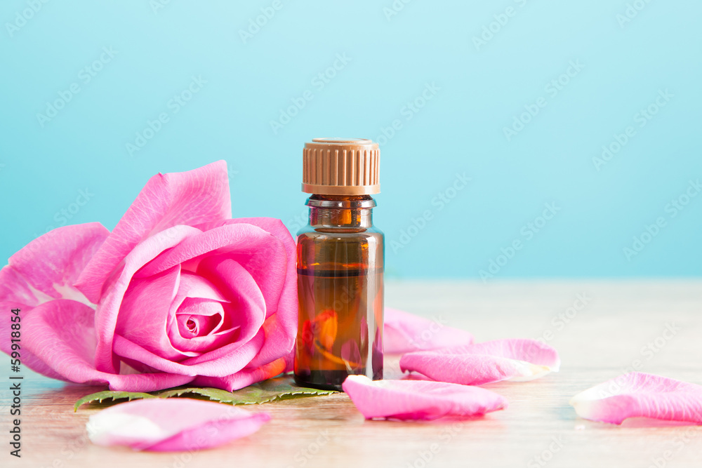 Bottle with aromatic oil and pink rose Bottle with aromatic oil and pink rose