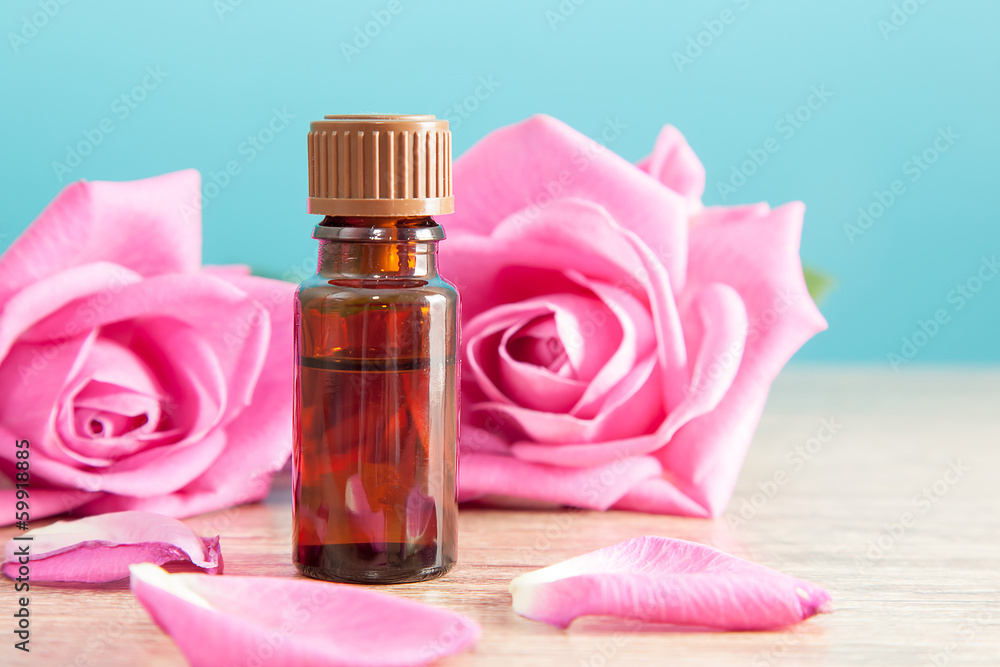 Bottle with aromatic oil and pink rose Bottle with aromatic oil and pink rose