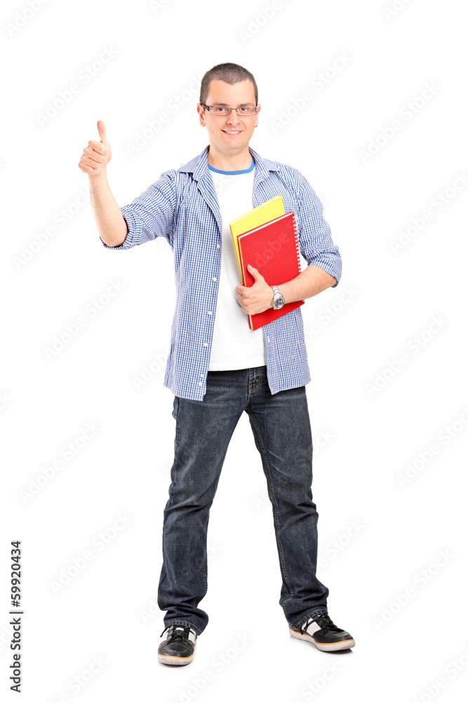 Full length portrait of male student with books giving thumb up Full length portrait of male student with books giving thumb up
