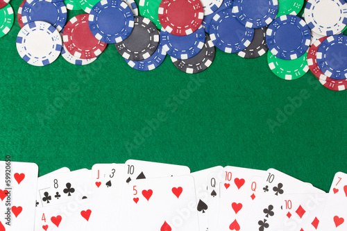 poker chips and cards on a green table background