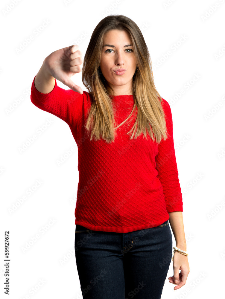 Young girl doing a bad signal over white background Young girl doing a bad signal over white background