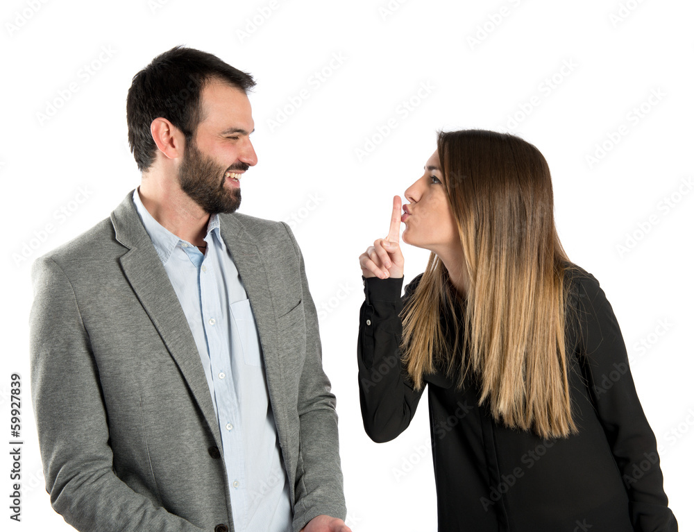 Young girl making silence gesture at her boyfriend Young girl making silence gesture at her boyfriend