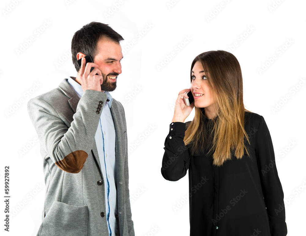 Couple talking to mobile over isolated background. Couple talking to mobile over isolated background.