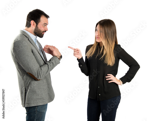 Girl pointing at her boyfriend over white background