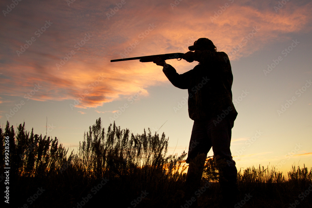 Hunter Silhouetted Shooting at Sunset Hunter Silhouetted Shooting at Sunset