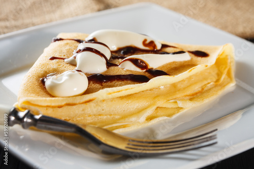 crepe with whipped cream and chocolate sauce photo