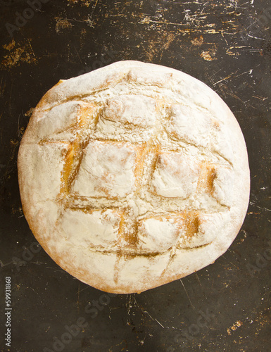 A whole English boule bread on distressed baking sheet