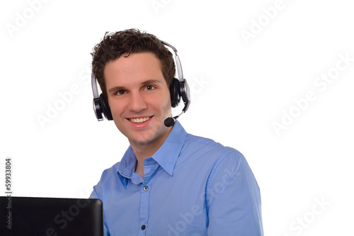 Junger Mann mit Headset im Callcenter oder im Webmeeting