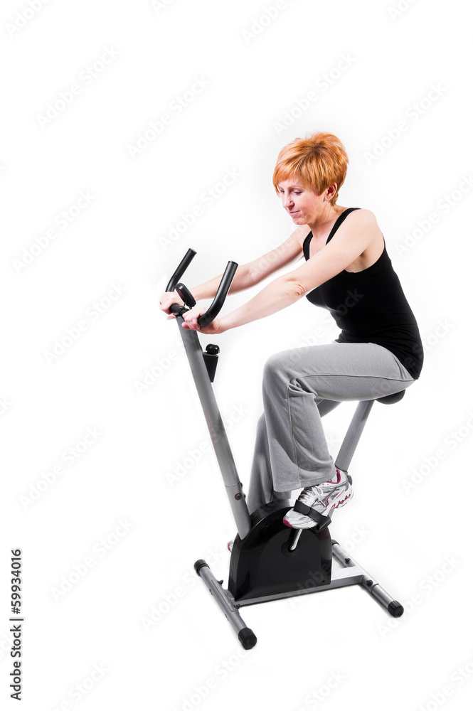 Woman doing sports on exercise bike Woman doing sports on exercise bike