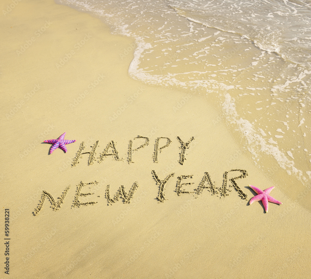 Fototapeta premium happy new year written in the sand