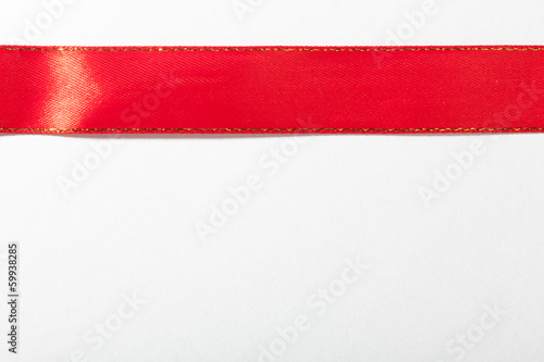 Shiny red ribbon on white background with copy space.