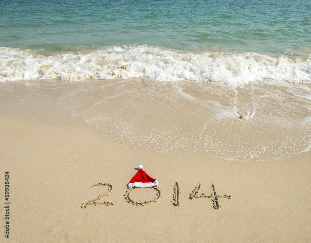 Year 2014 hand written on the white sand in front of the sea Year 2014 hand written on the white sand in front of the sea