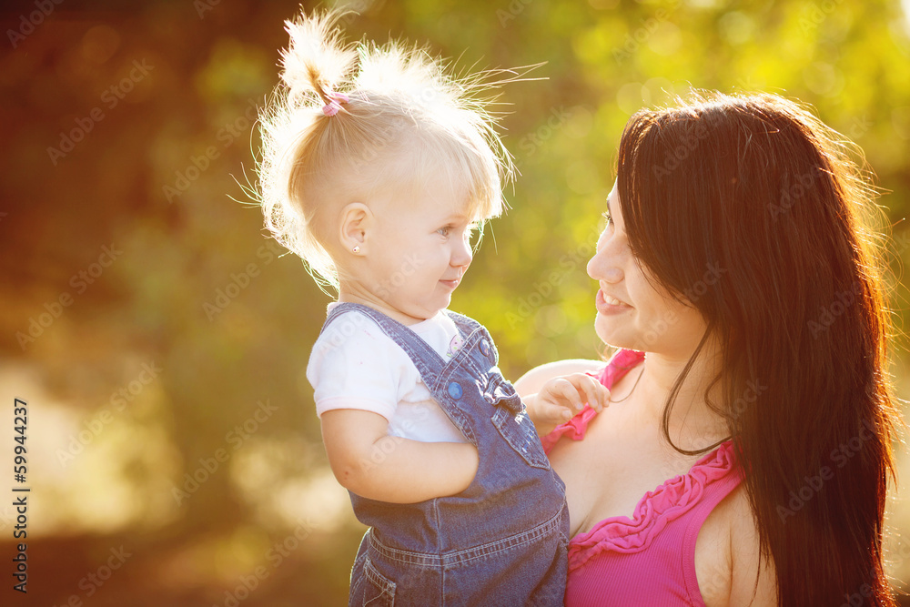 Naklejka premium Young mother with child outside on a summer day