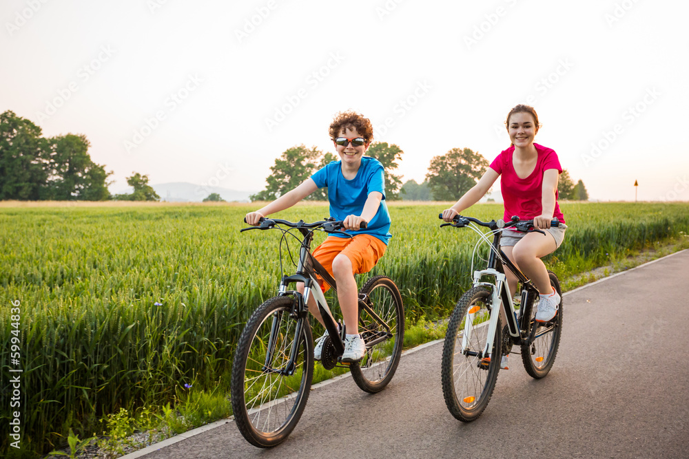Healthy lifestyle - teenage girl and boy biking Healthy lifestyle - teenage girl and boy biking