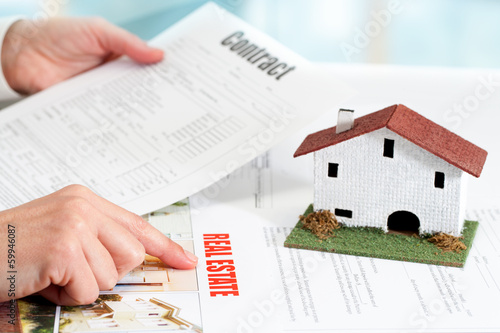 Hands reviewing real estate property documents.