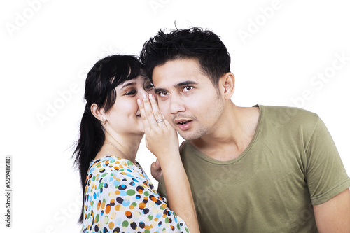 Young woman whispering a secret news