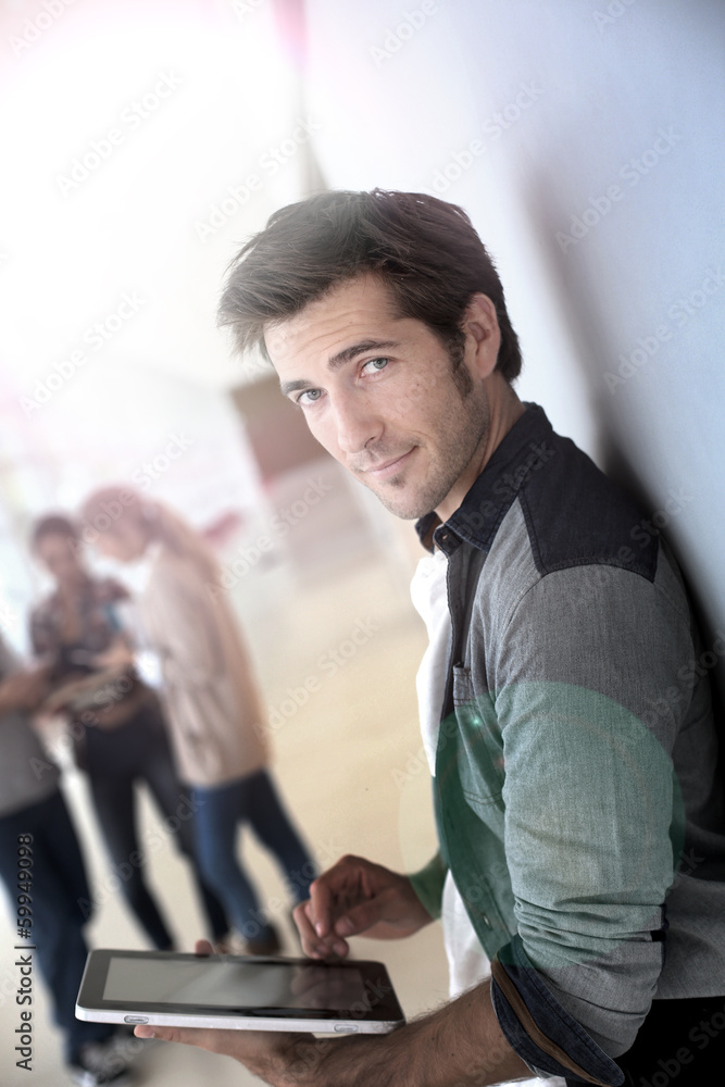Young man in college campus connected on tablet Young man in college campus connected on tablet