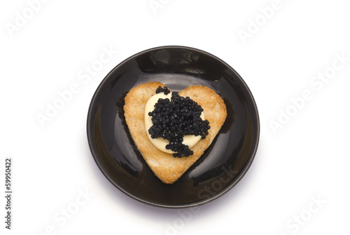 Small Plate with Heart-Shaped Toast with Caviar on White Sauce i