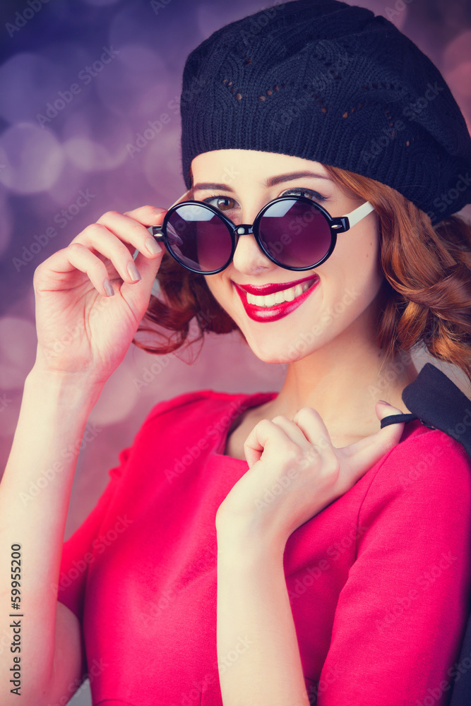 Redhead in sunglasses on red background Redhead in sunglasses on red background