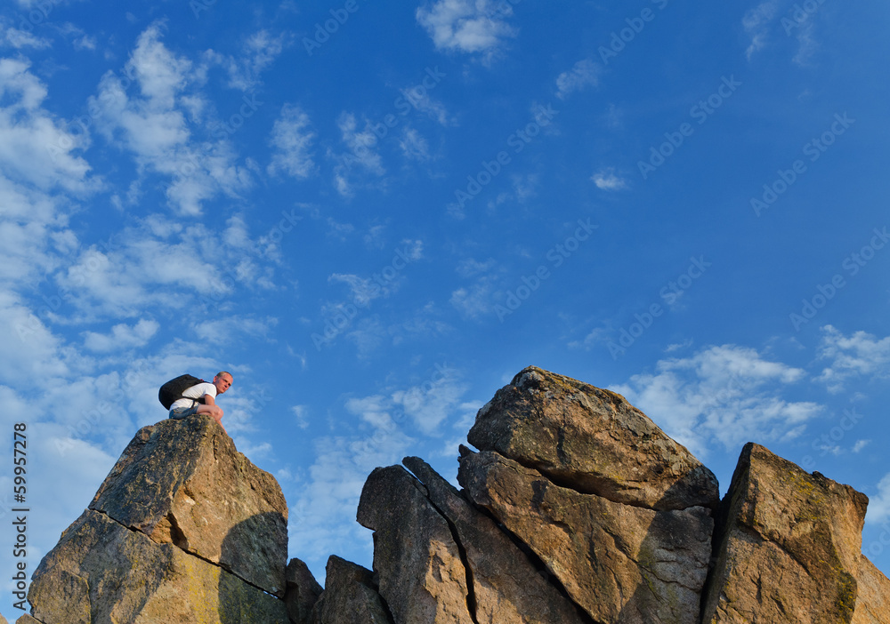 Backpacker on a distant rocky mountain peak
