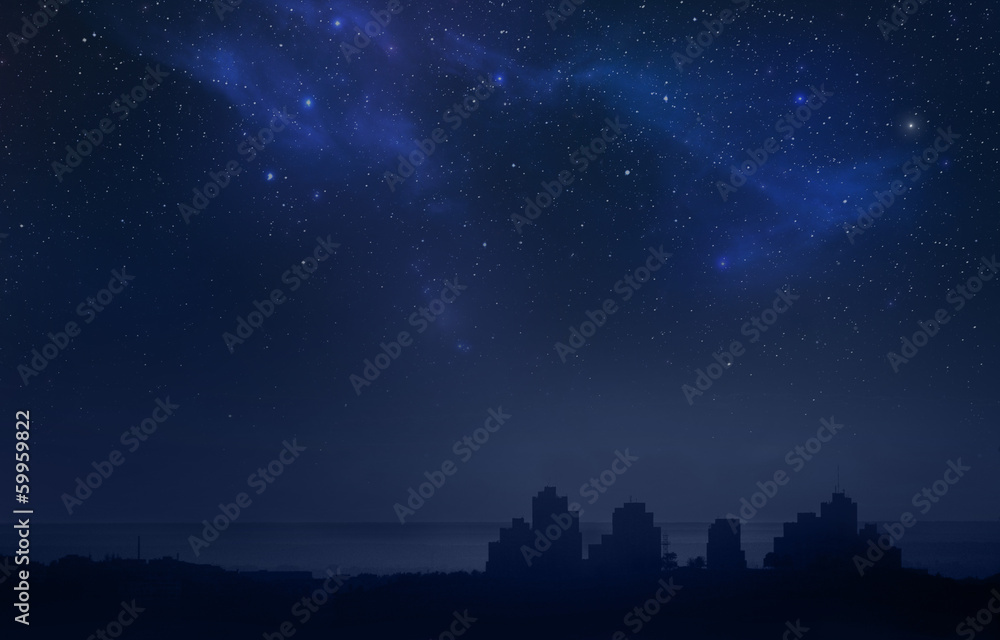 City landscape at night with star filled sky, nebula and galaxy