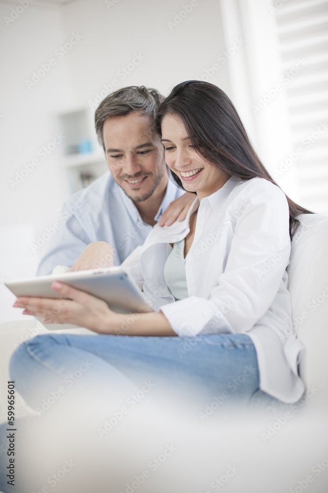 Cheerful couple using digital tablet at home Cheerful couple using digital tablet at home