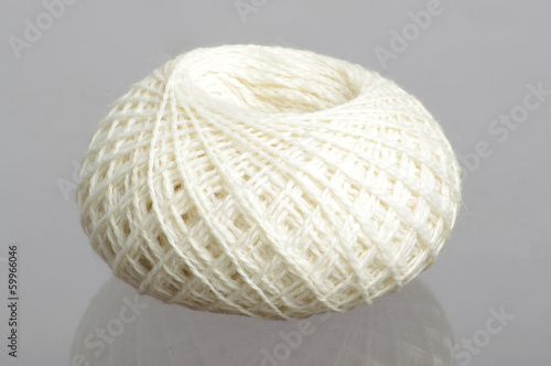 White spool of yarn on studio grey background