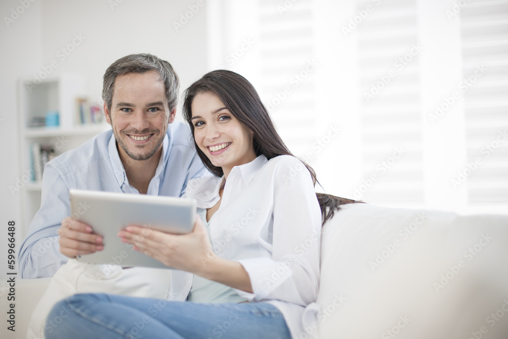 Cheerful couple using digital tablet at hom Cheerful couple using digital tablet at hom