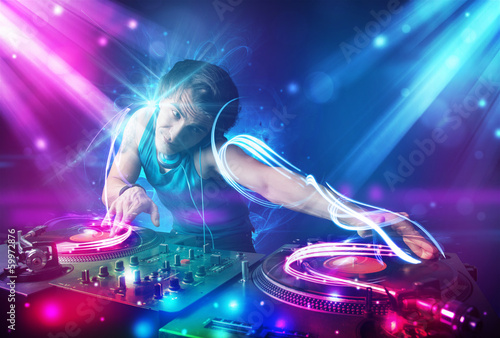 Energetic Dj mixing music with powerful light effects photo