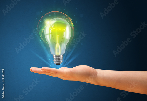 Glowing lightbulb in the hand of a woman