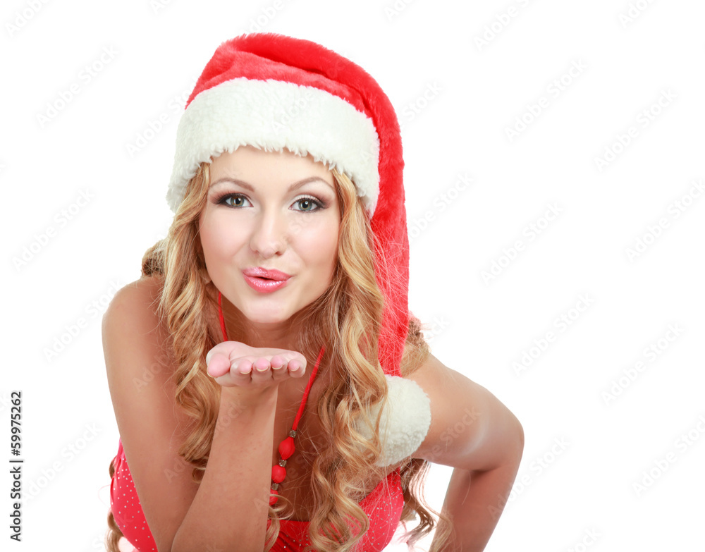 Smiling young woman in Santa hat blowing air kiss Smiling young woman in Santa hat blowing air kiss