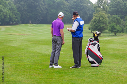 Caddy pointing out a hazard to golfer