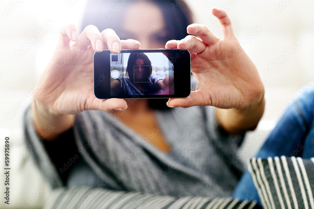 woman making self photo with smartphone. Focus on smartphone