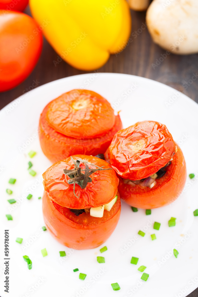 Three stuffed tomatoes on a white plate Three stuffed tomatoes on a white plate