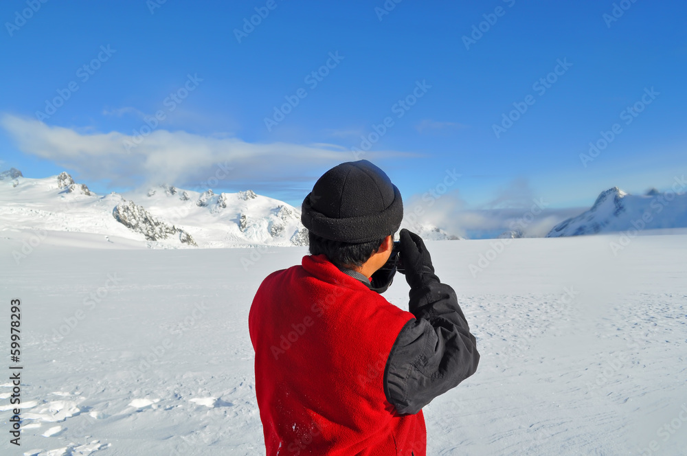 Photographer shooting at top of ice mountain