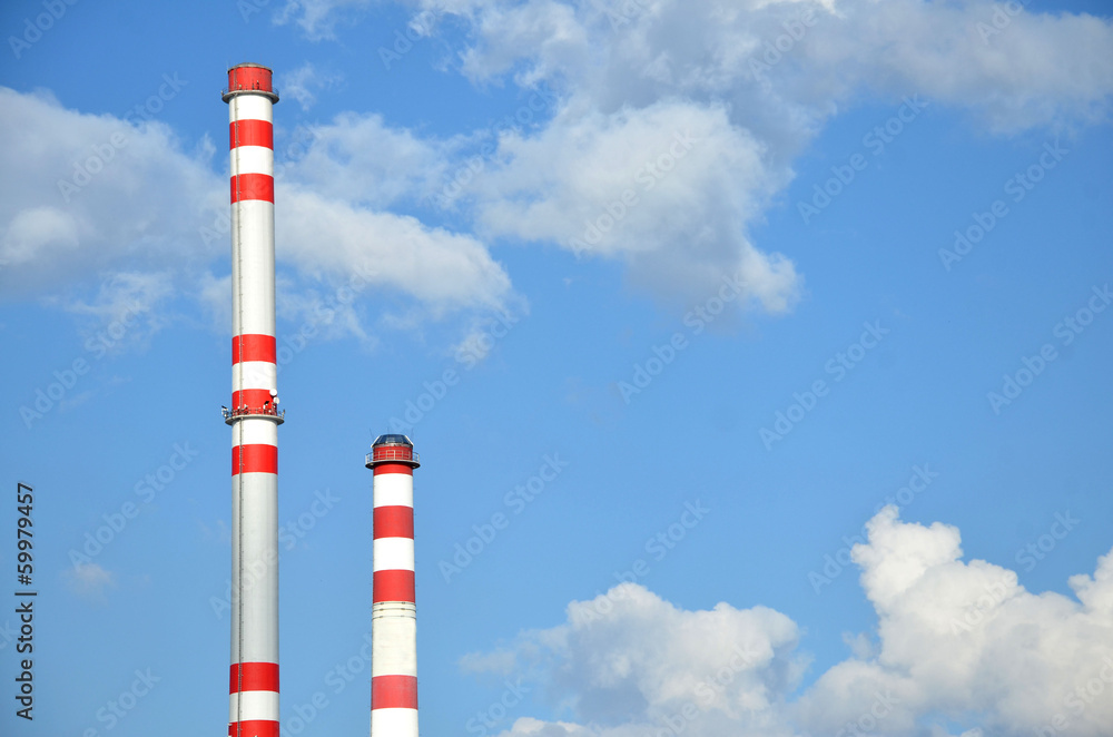 Two factory chimneys with sky in the background Two factory chimneys with sky in the background