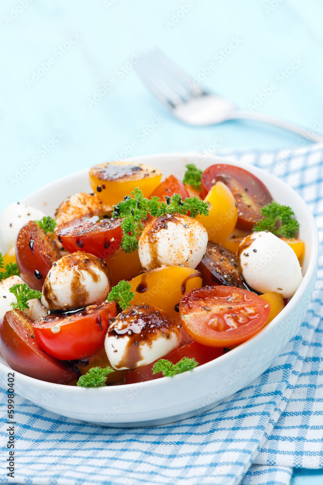 bowl of salad with mozzarella, balsamic and colorful cherries