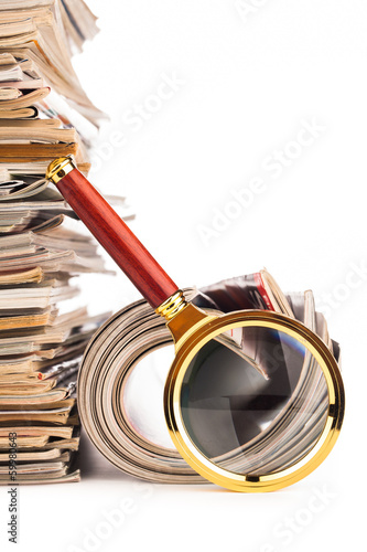 pile of newspapers and magnifying glass