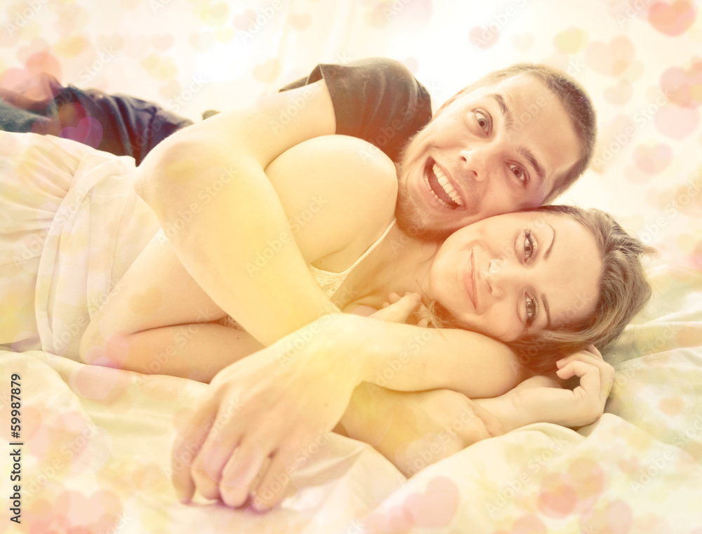 Lovely couple hugging on their bed at home Lovely couple hugging on their bed at home