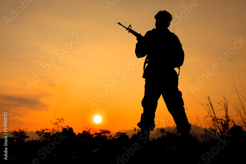 Soldier and gun in silhouette shot