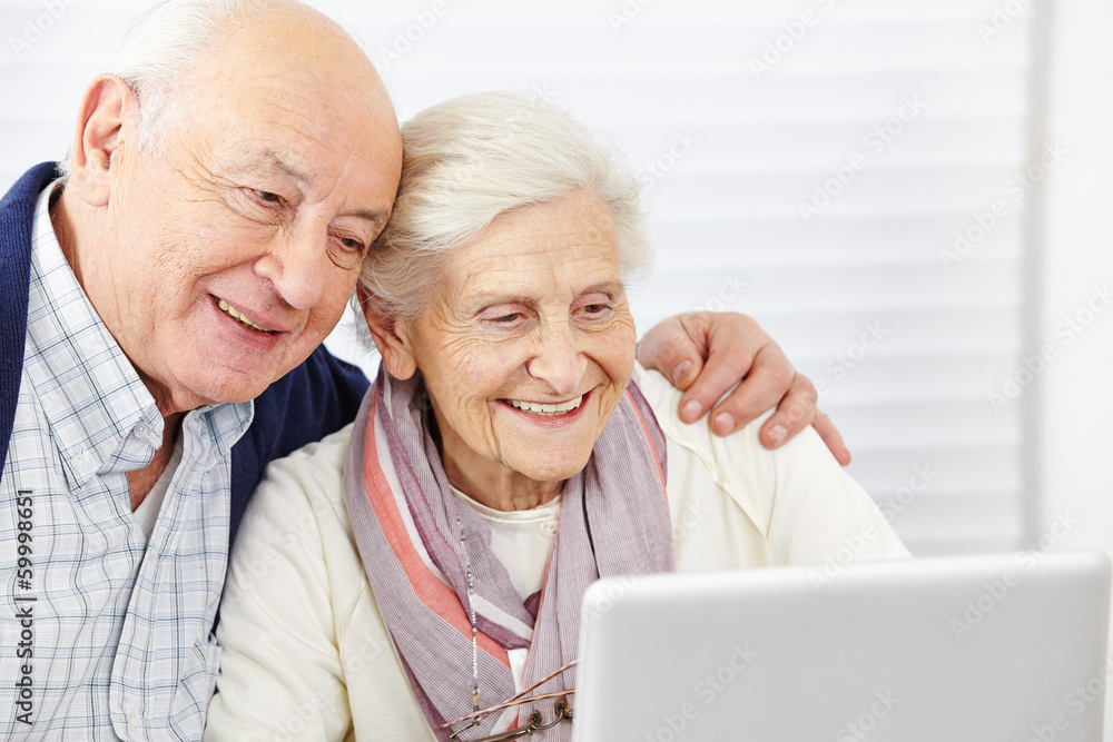 Paar Senioren schaut auf Computer Paar Senioren schaut auf Computer