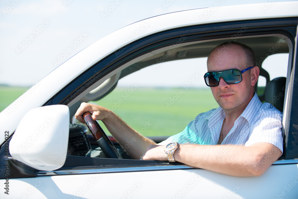 Naklejka premium Happy adult man in white new car at nature