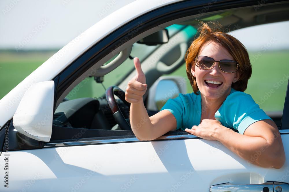 woman in white new car at nature with thumbs up sign
