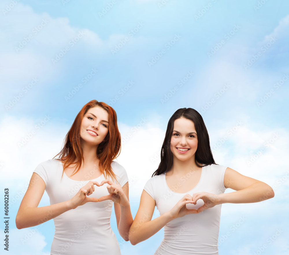 two smiling girls showing heart with hands two smiling girls showing heart with hands