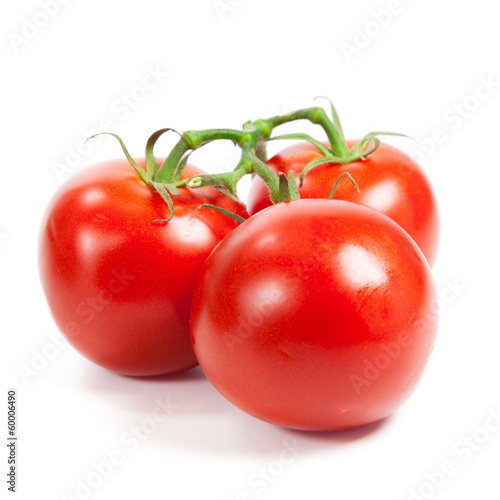 three fresh tomatoes with green leaves isolated on white backgro