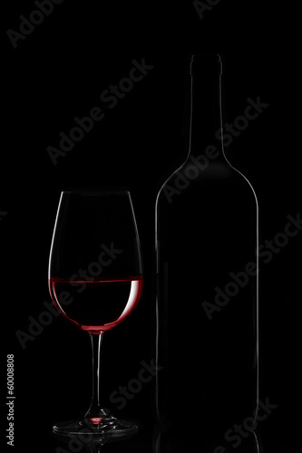 Red wine bottle and wine glass on black background