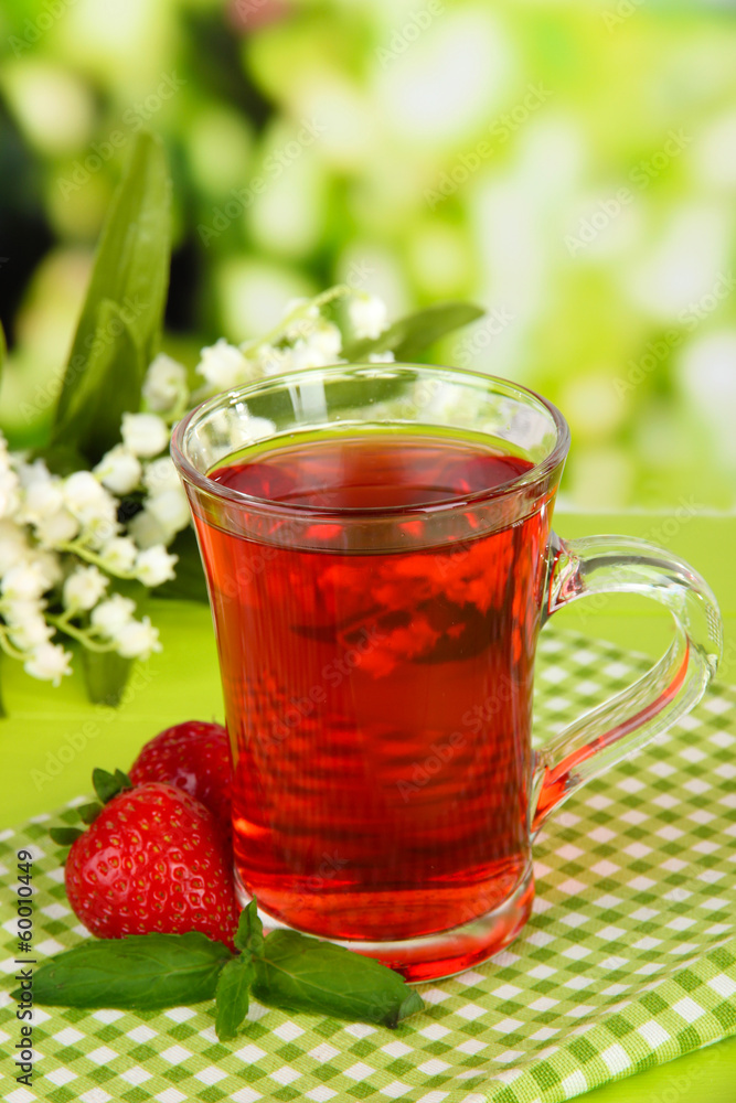 Delicious strawberry tea on table on bright background Delicious strawberry tea on table on bright background