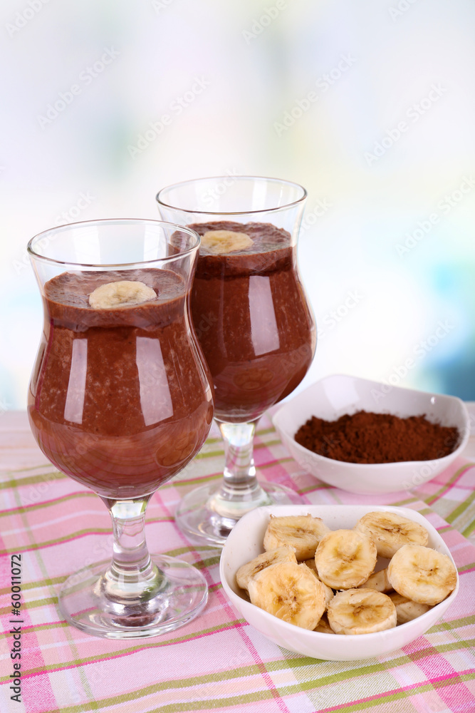 Cocktails with banana and chocolate on table on light Cocktails with banana and chocolate on table on light