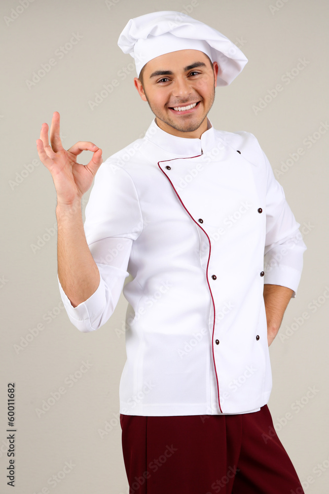 Professional chef in white uniform and hat, on gray background Professional chef in white uniform and hat, on gray background