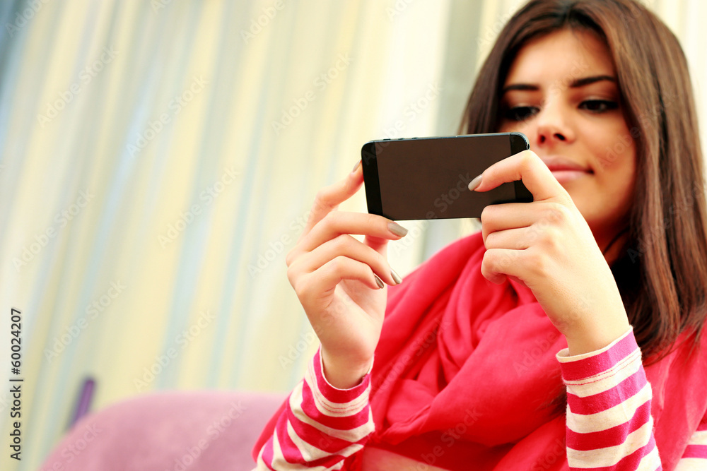 Young beautiful woman holding smartphone. Focus on smartphone. Young beautiful woman holding smartphone. Focus on smartphone.